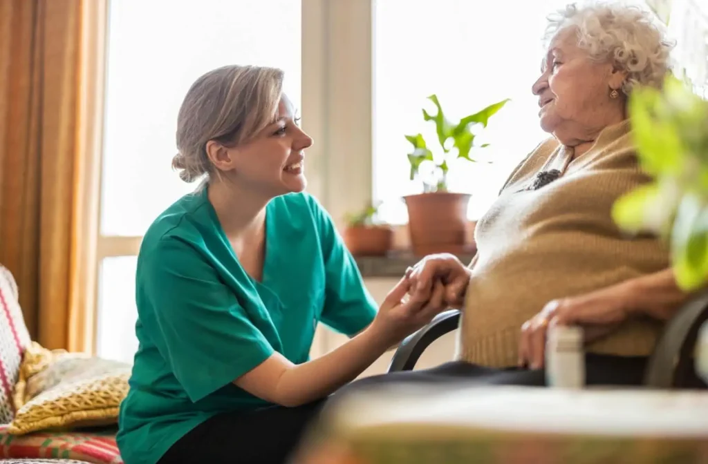 Caregiver comforting an elderly woman during a conversation in a cozy indoor setting, highlighting compassion and support in senior care.
